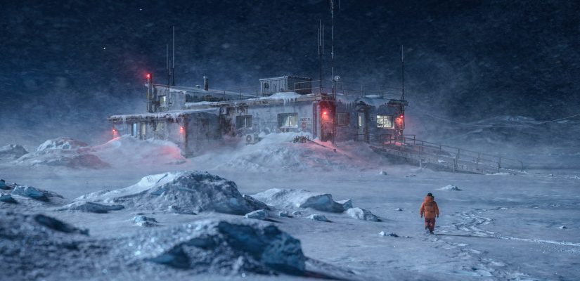 Surreal arctic landscape photography, winter polar night, an abandoned research station building buried in snow, red warning lights faintly blinking on antennas under deep snowdrifts, a lone figure in an orange parka walking away from the station into a whiteout blizzard, empty icy expanse, low visibility, cinematic atmosphere, soft focus on blowing snow, mysterious and melancholic mood, dark blue twilight, Fujifilm Pro 400H (сгенерировано FLUX)